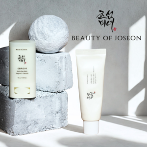 Beauty of Joseon sun stick and sunscreen tube on white stone blocks
