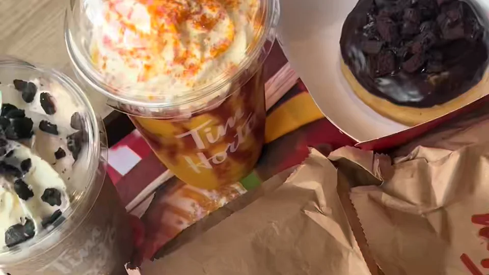 Tray with a Tim Hortons iced drink, a cookies and cream cup and a chocolate cookie-topped doughnut