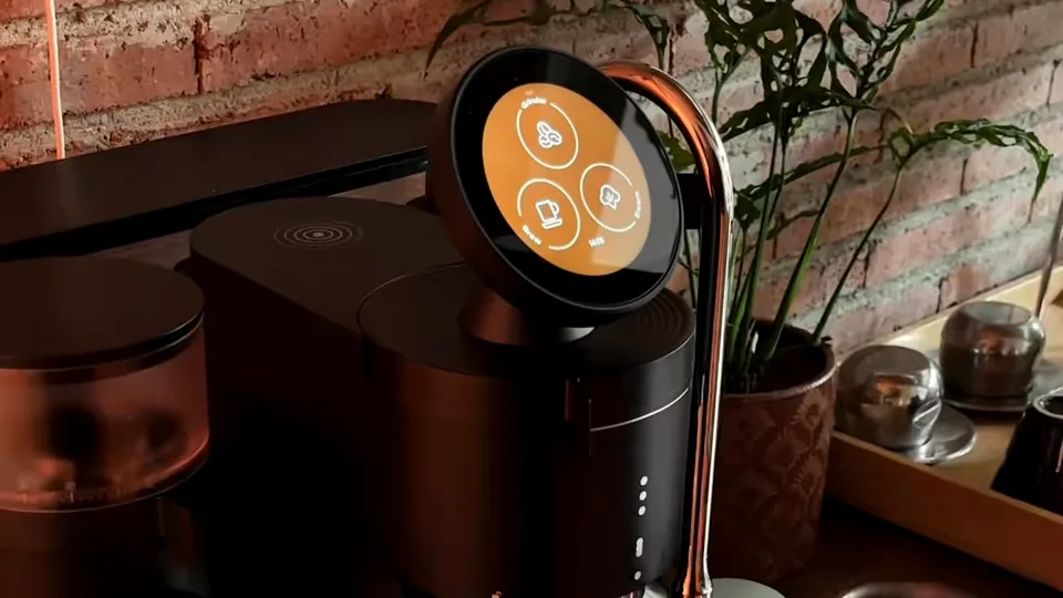 Close view of a black and copper coffee machine with a round touchscreen showing drink options