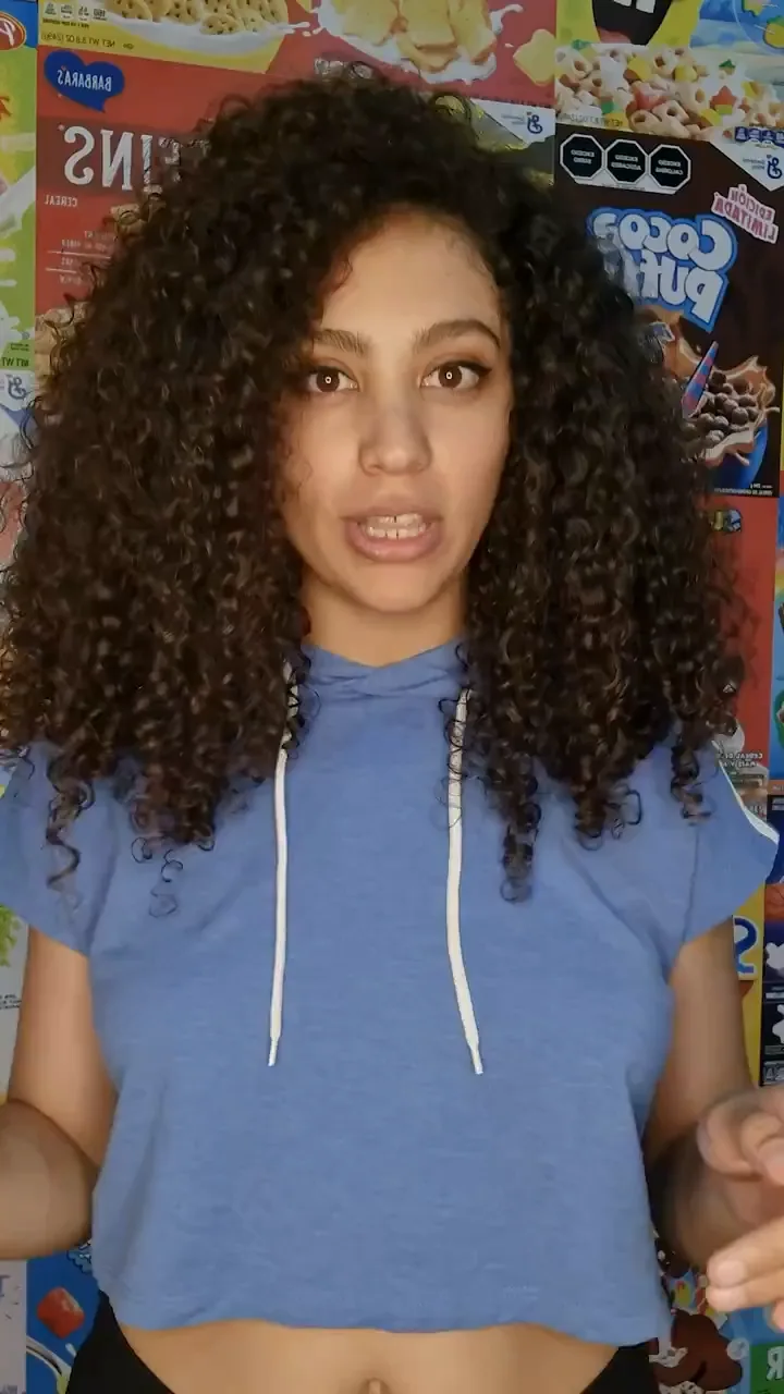 Creator speaking to camera in front of a wall of cereal boxes