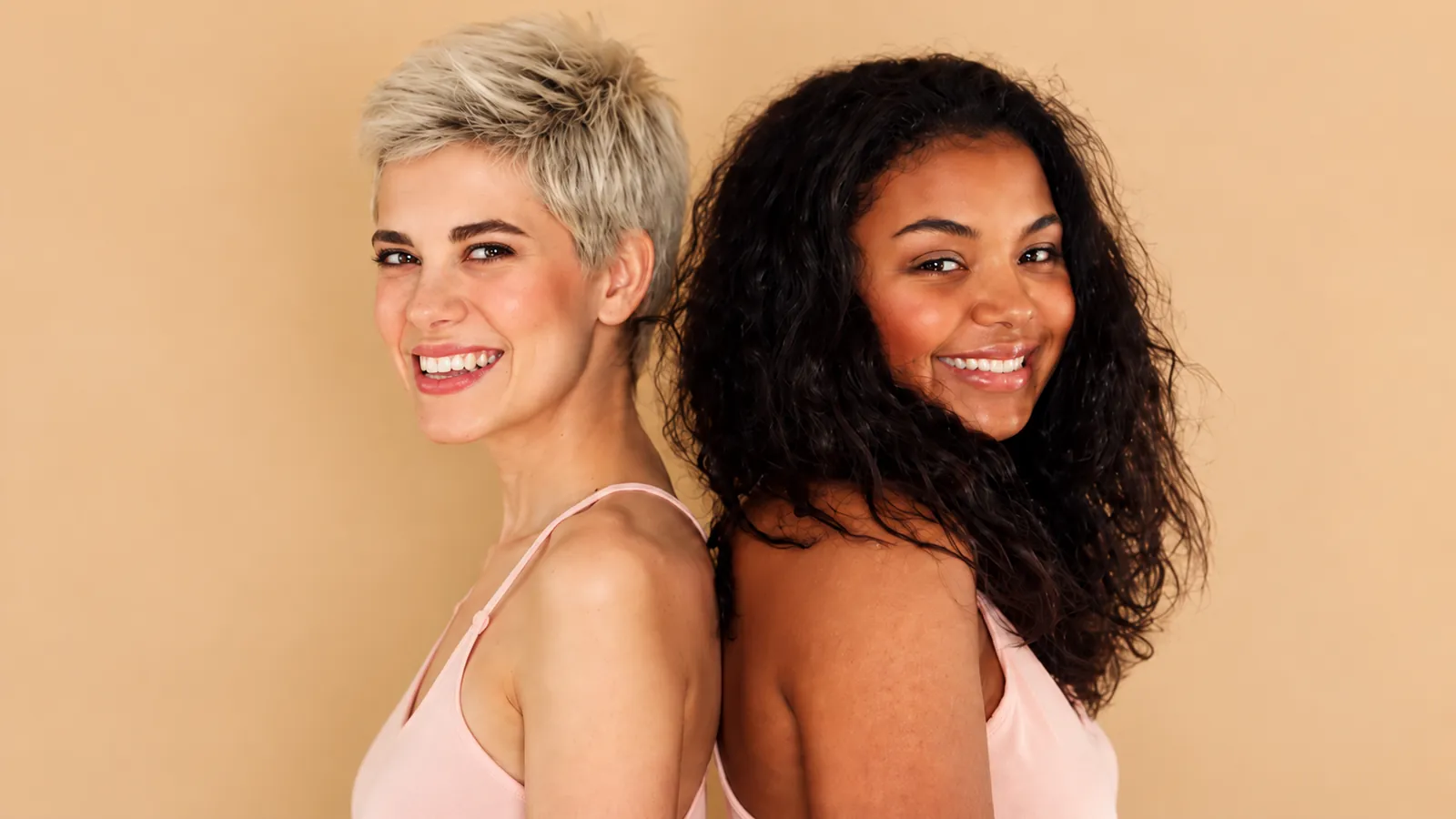 Two creators smiling side by side against a warm backdrop