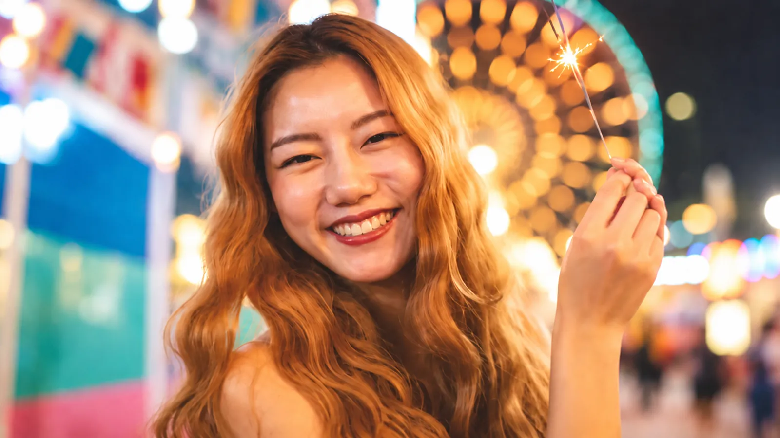 Smiling creator holding a sparkler at a night fair