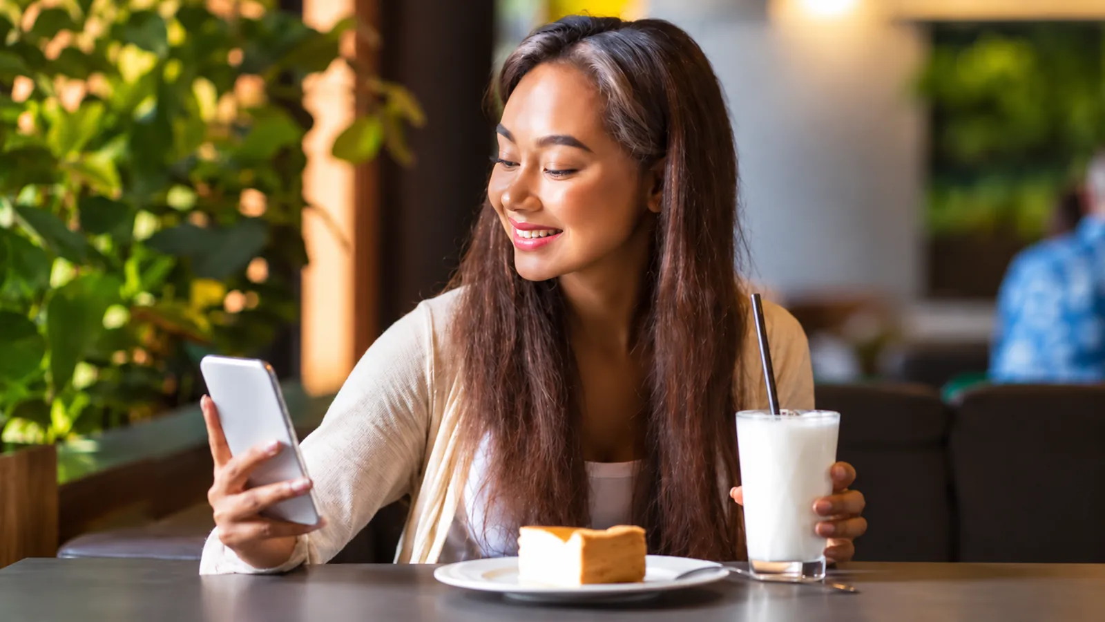 Creator smiling at her phone in a cafe