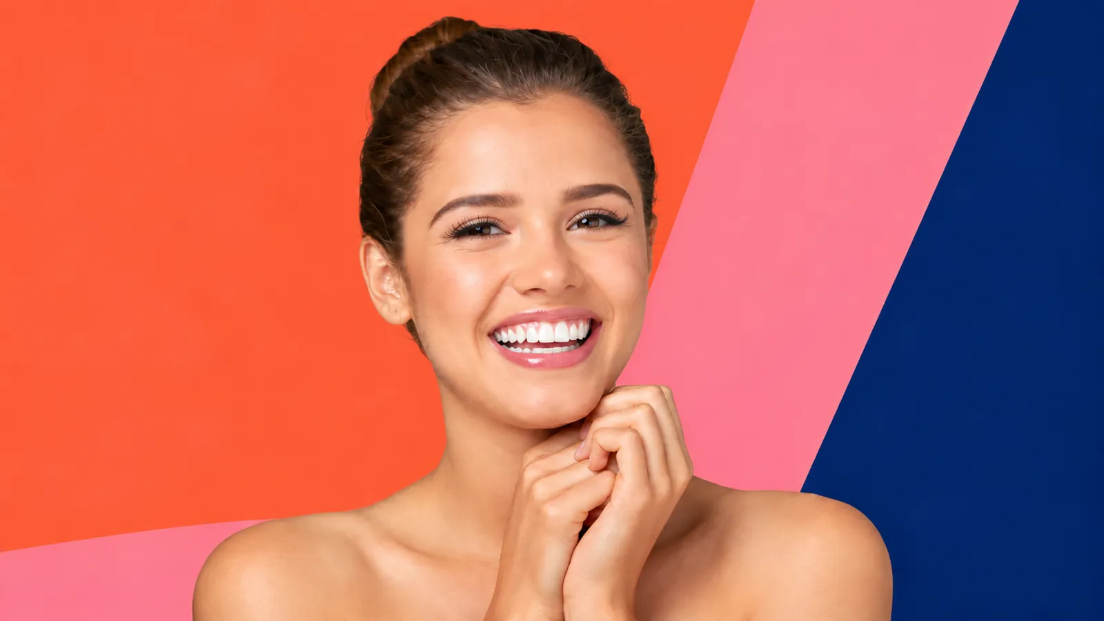 Smiling woman against bold orange, pink and blue colour blocks