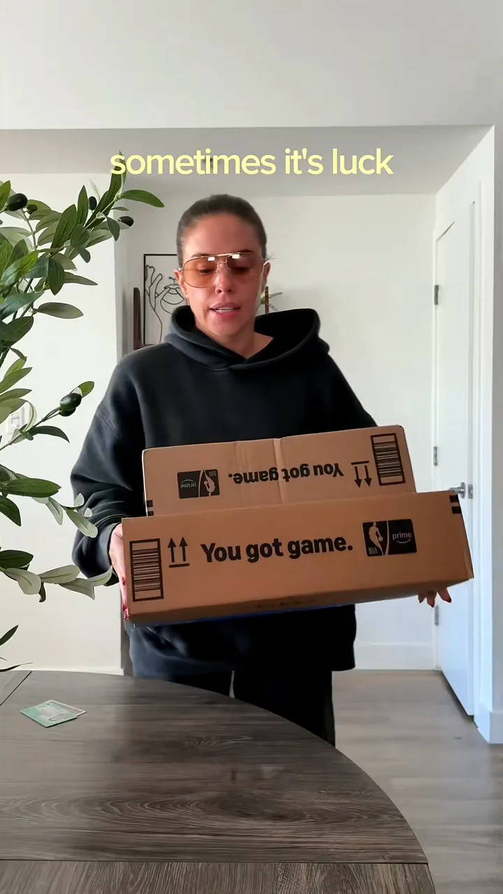 Creator in tinted glasses carrying two delivery boxes to a table