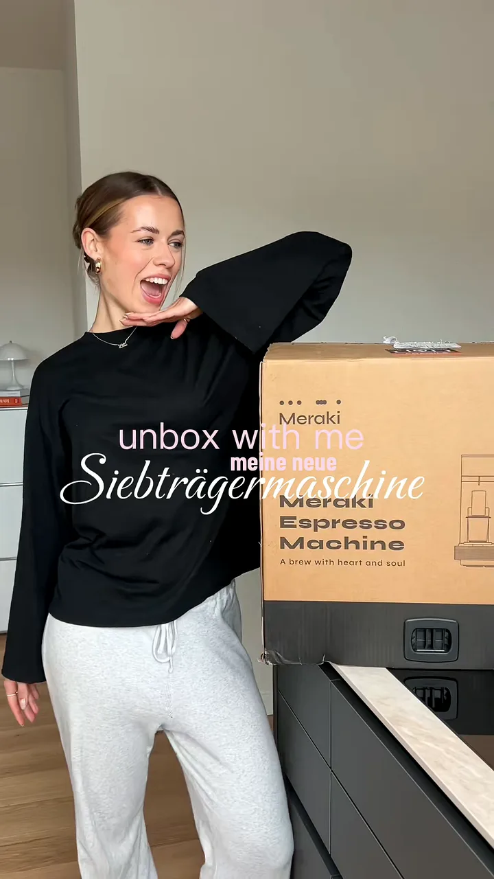 Creator posing beside a large delivery box before opening it