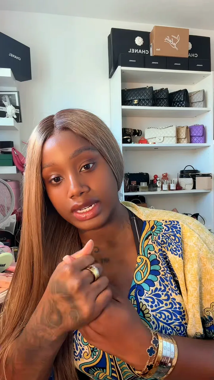 Creator talking to camera in front of shelves of handbags