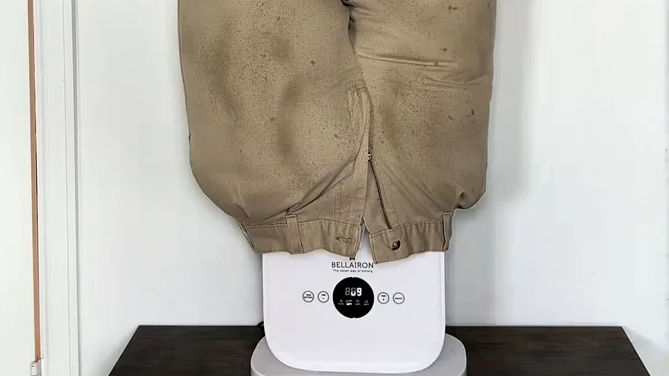 Pair of damp, spotted khaki trousers drying on a white Bellairon unit set on a dark table