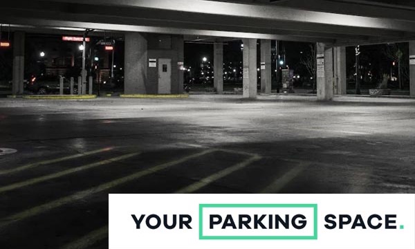 Empty multi-storey car park at night with the YourParkingSpace logo