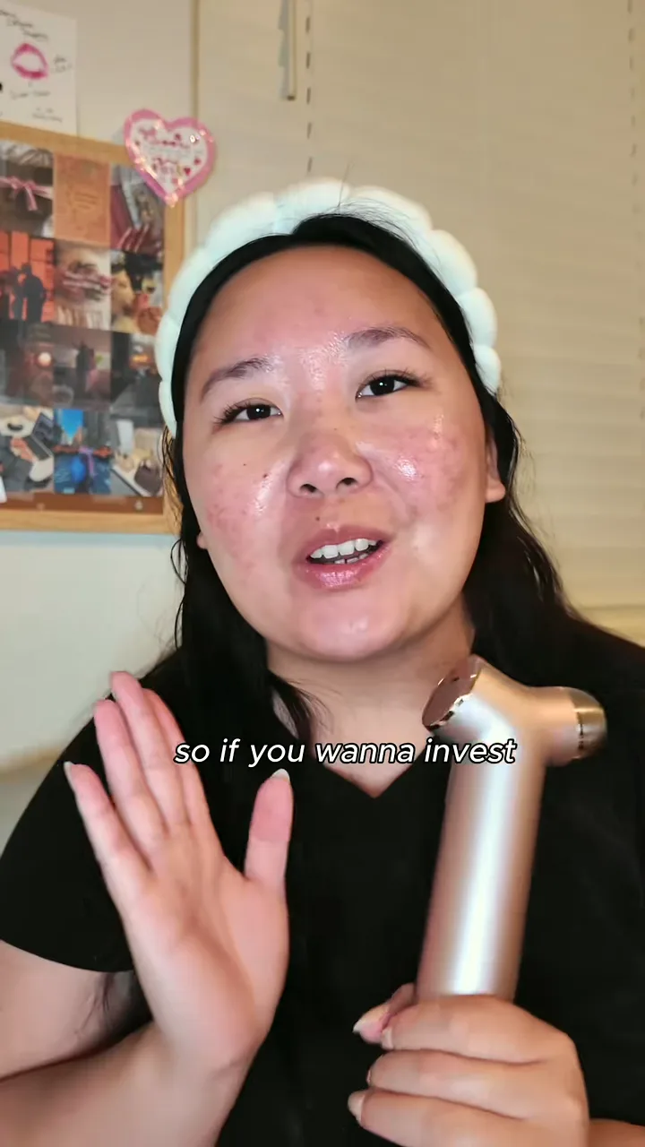 Creator in a headband smiling and holding a skincare device