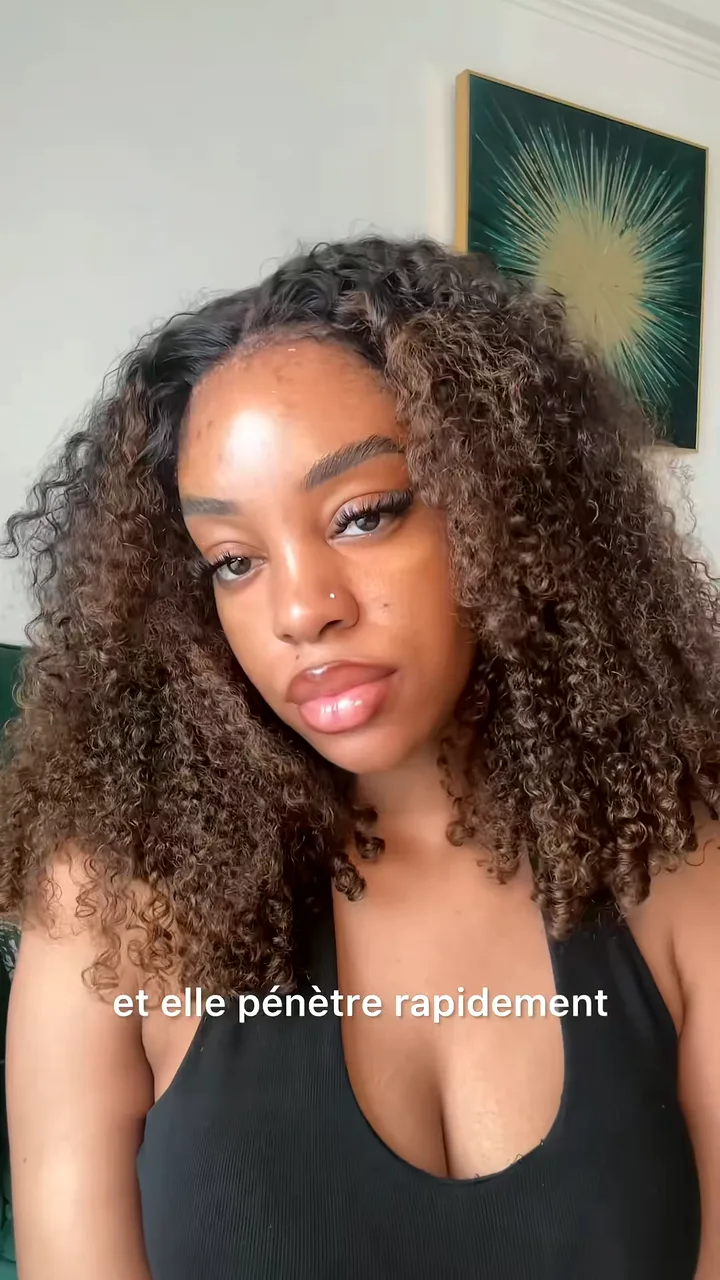 Creator with long curly hair talking to camera in a white room